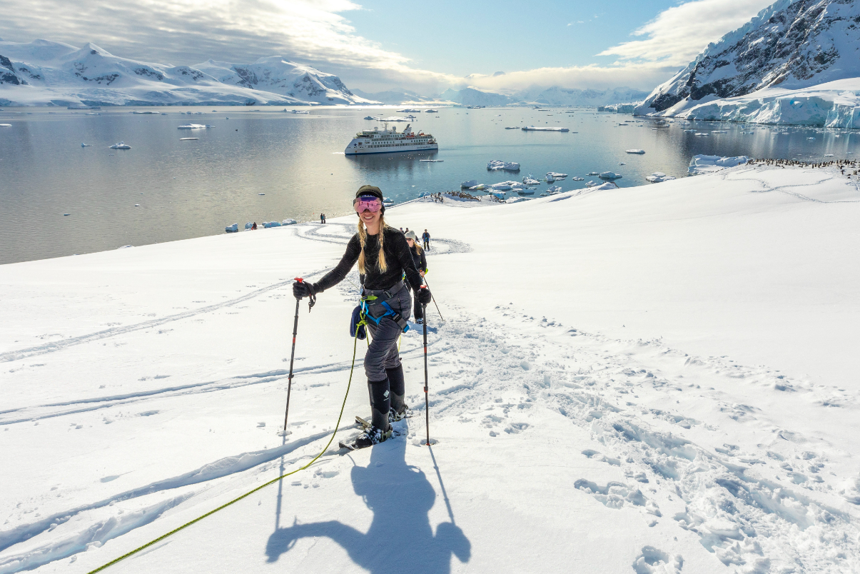 Aurora - Antarctica Hiker with ship in background in Antarctica