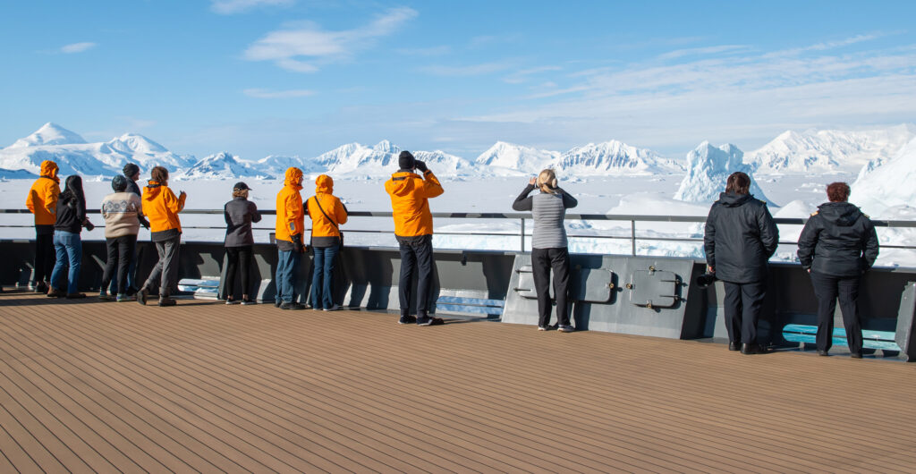 a group of people stood on the deck of an expedition ship