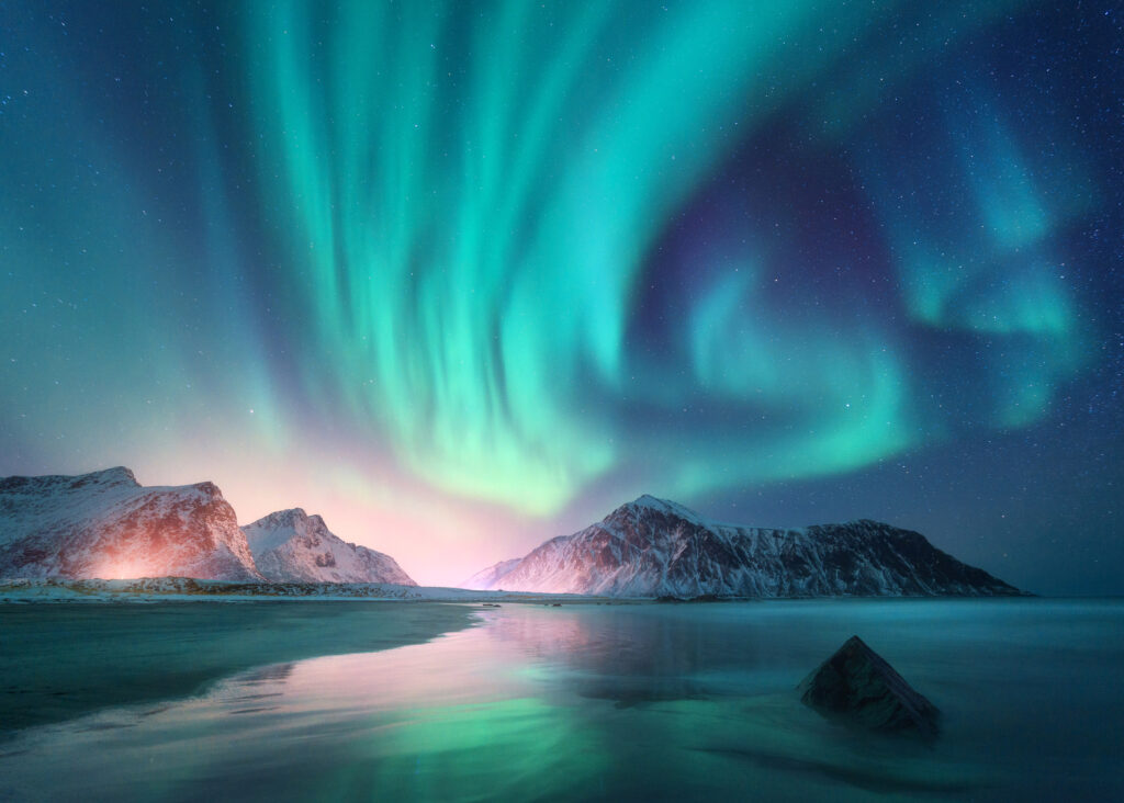 the northern lights in the arctic with sea and mountains
