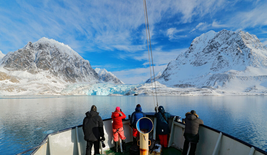 people standing on the deck of a ship in the Arctic during the spring best time to go to the Arctic