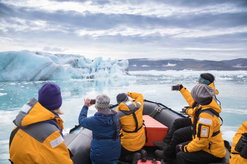 guests photographing iceberg from zodiac