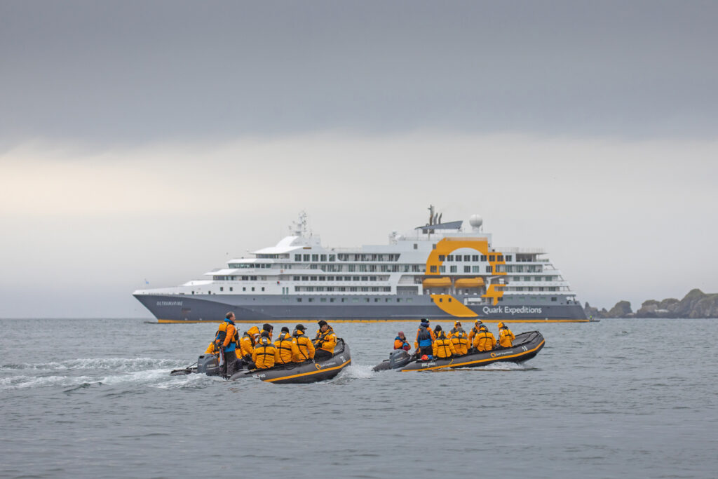 2 zodiacs with ultramarine cruise ship in the background